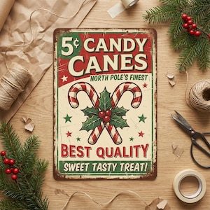 Peut inclure: Panneau m&eacute;tallique vintage avec une finition vieillie, annon&ccedil;ant "5&cent; CANDY CANES". Le panneau pr&eacute;sente des cannes en sucre rouges et blanches, du houx et le texte "NORTH POLE'S FINEST" et "BEST QUALITY SWEET TASTY TREAT!" sur fond cr&egrave;me.
