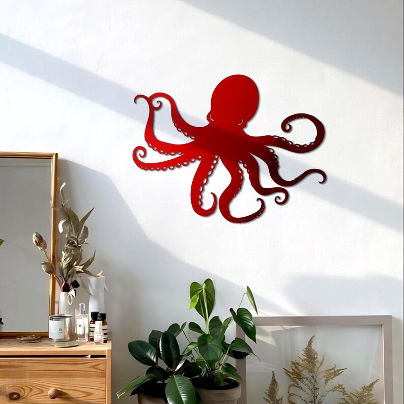 May include: Red metal octopus wall decor with eight tentacles. The octopus is mounted on a white wall.