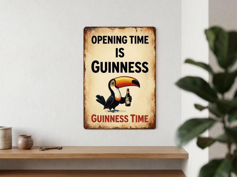 May include: A vintage-style metal sign with a distressed finish. The sign features a cartoon toucan holding a bottle of Guinness. Text on the sign reads "OPENING TIME IS GUINNESS" and "GUINNESS TIME". The sign is mounted on a white wall.