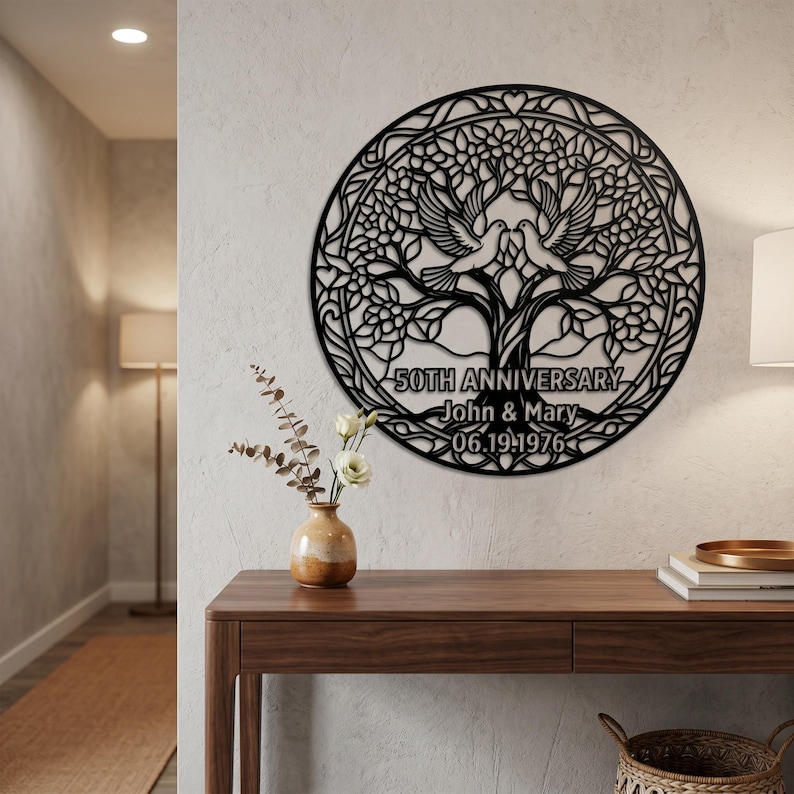 May include: A circular black metal wall art piece featuring a tree with two doves perched in the branches. The design includes the text 50TH ANNIVERSARY, John & Mary, and 06.19.1976. The intricate cutout pattern is framed by a circular border with hearts.