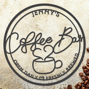 以下が含まれることがあります： 「Jenny's Coffee Bar」の文字が入った黒い金属製のサイン。円形デザインで、コーヒーカップのグラフィックと「Open Daily Freshly Brewed」の文字が含まれています。右側にはコーヒー豆が散らばっています。