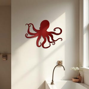 May include: A red metal octopus wall sculpture with curled tentacles. The sculpture is mounted on a white wall in a bathroom setting.