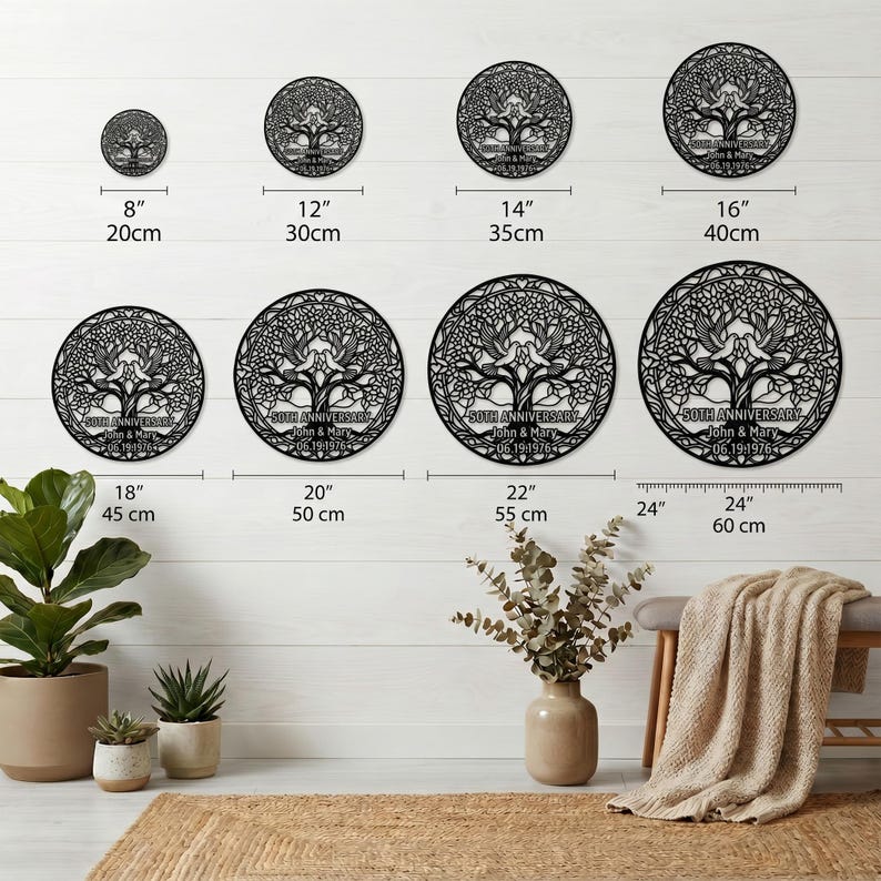 May include: A collection of eight circular black metal wall art pieces featuring a tree of life design with two birds, personalized with the text 50TH ANNIVERSARY, John & Mary, and 06.19.1976, ranging in size from 8 inches to 24 inches in diameter.