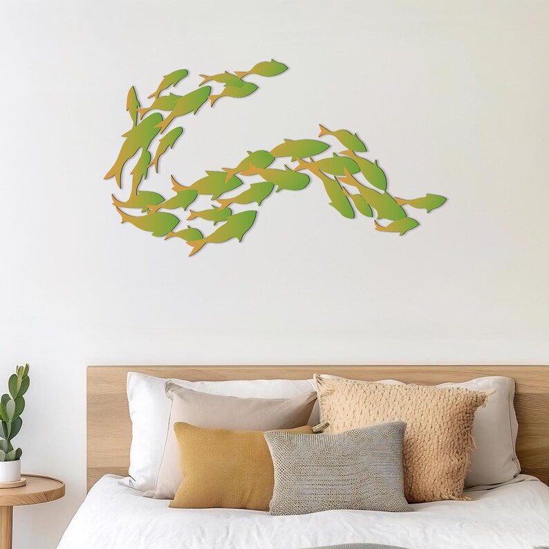 May include: A white bed with a wooden headboard and a green fish wall decor. The bed is made with white bedding and has several throw pillows in beige and mustard yellow.