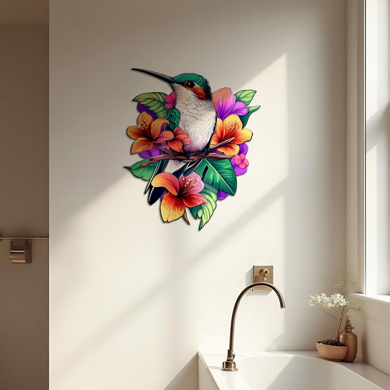 May include: A colourful hummingbird with green and white feathers perched on a branch with pink, orange and yellow flowers. The hummingbird is surrounded by green leaves.