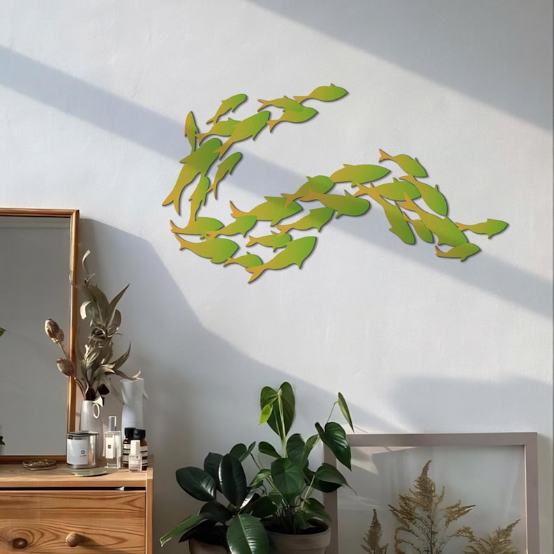 May include: A wall decor featuring a school of fish in a green and yellow gradient. The fish are arranged in a curved shape, creating a dynamic and modern design.