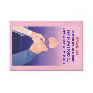 Puede incluir: Un imán rectangular rosa con una ilustración de dos manos unidas por un hilo rojo, un corazón y el texto: "Aquellos que están destinados a cruzarse están unidos por un hilo rojo invisible."