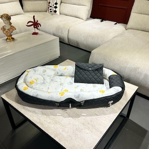 Bolsa de cuidado para bebés Orthomatt, exterior de piel sintética negra, funda interior de algodón transpirable y reemplazable, con certificación Oeko-Tex Standard, portátil, para recién nacidos