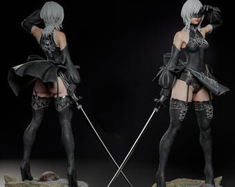 May include: A detailed figurine of a character in a black outfit with a short skirt, gloves, and high boots. The character has short white hair and is holding a sword. The figure is posed on a rocky base, with a second figure in the background.
