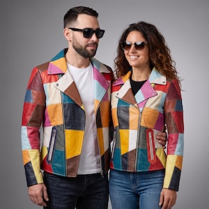 May include: Two matching motorcycle jackets constructed from multi-colored leather patches in shades of red, yellow, blue, brown, pink, and cream. Each jacket features a wide notched lapel, silver-toned metal zippers, and long sleeves.