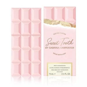 Puede incluir: Un juego de botella y caja de perfume rosa. La botella tiene forma de tableta de chocolate. La caja presenta el texto "Sweet Tooth" de Sabrina Carpenter e indica que la fragancia es una fragancia deliciosa con ingredientes 100% indulgentes. La botella contiene 75 ml.