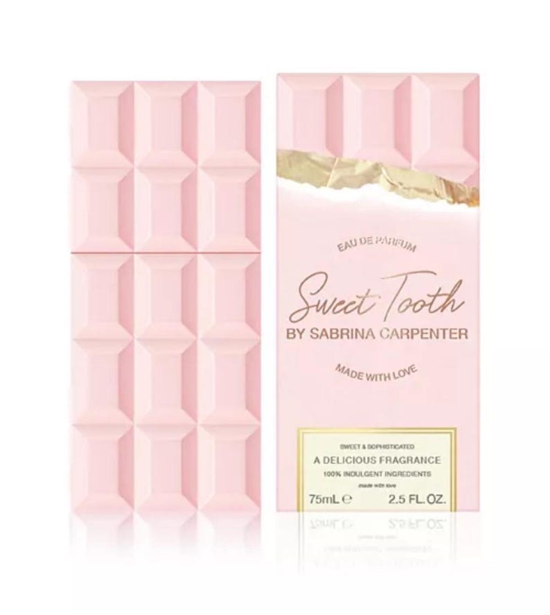 Puede incluir: Un juego de botella y caja de perfume rosa. La botella tiene forma de tableta de chocolate. La caja presenta el texto "Sweet Tooth" de Sabrina Carpenter e indica que la fragancia es una fragancia deliciosa con ingredientes 100% indulgentes. La botella contiene 75 ml.