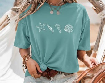 Regalo estivo per gli amanti dell'oceano: maglietta con conchiglie e motivi marini per donna.