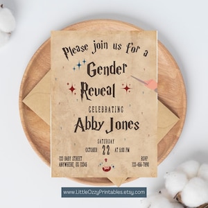 May include: A gender reveal invitation with a parchment-like background. The invitation reads "Please join us for a Gender Reveal Celebrating Abby Jones" with event details. The invitation is on a wooden plate with an envelope.