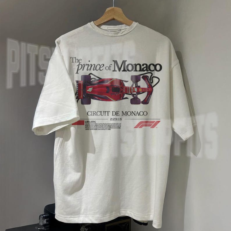 May include: White t-shirt with a red Formula 1 race car graphic and the text "The prince of Monaco" and "Circuit de Monaco".