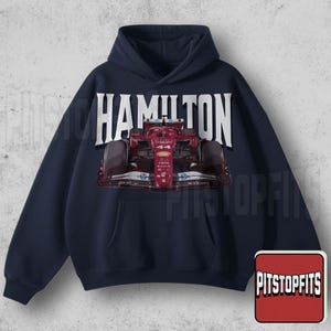 Peut inclure: Sweat à capuche bleu marine avec un graphisme de voiture de course de Formule 1. Le mot "HAMILTON" est imprimé en grandes lettres blanches au-dessus de la voiture. La voiture est rouge et noire avec le numéro 44. Une poche est visible à l'avant.