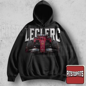 May include: Black hooded sweatshirt featuring a red Formula 1 race car graphic with the name "LECLERC" in large white letters across the top. The sweatshirt has a front pocket and a drawstring hood. The Pitstopfits logo is in the bottom right corner.