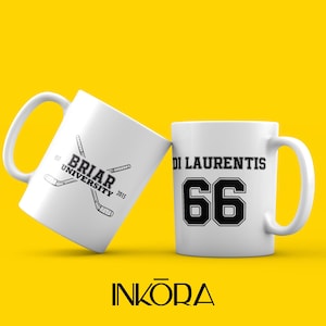 Puede incluir: Dos tazas de cerámica blanca con texto y gráficos negros sobre un fondo amarillo. Una taza muestra "Briar University 2015" con palos de hockey cruzados. La otra taza tiene "Di Laurentis 66".