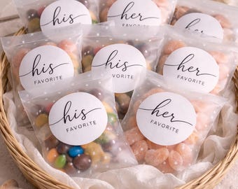 May include: A wicker basket containing cellophane bags of sweets. Each bag is sealed with a white sticker reading "his favorite" or "her favorite" in cursive. The sweets are in various colours.