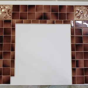May include: A fireplace surround assembly featuring square brown glazed ceramic tiles with a dark gradient finish. The top corners include decorative relief tiles depicting a figure in a seated pose, arranged in a rectangular frame layout.