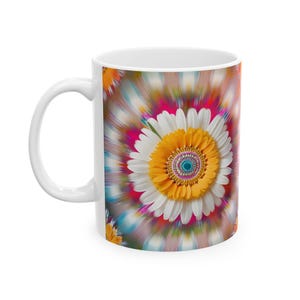Può includere: Tazza in ceramica bianca con un design astratto colorato che presenta una grande margherita bianca con un centro giallo e uno sfondo a spirale.