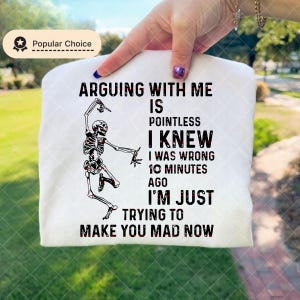 May include: White t-shirt with a skeleton graphic and the text "ARGUING WITH ME IS POINTLESS I KNEW I WAS WRONG 10 MINUTES AGO I'M JUST TRYING TO MAKE YOU MAD NOW". The shirt has a "Popular Choice" badge.