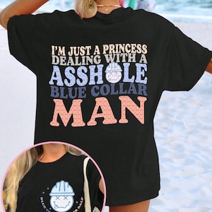 Może przedstawiać: Czarny t-shirt z napisem "I'M JUST A PRINCESS DEALING WITH A ASSHOLE BLUE COLLAR MAN" w różnych kolorach. Mniejszy obrazek przedstawia kask budowlany z uśmiechniętą buzią i napisem "BLUE COLLAR - BETTER HALF".