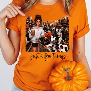 May include: An orange t-shirt featuring a graphic of a person holding a coffee in a store filled with Halloween decorations, including pumpkins, skeletons, and ghosts. The text "just a few things" is printed below the graphic in black script.