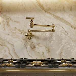 Könnte beinhalten: Eine luxuriöse Kücheneinrichtung mit einem Gasherd aus Edelstahl mit Messingakzenten. Ein Messing-Topffüller ist an der Marmor-Rückwand montiert. Kupferpfannen und Utensilien hängen in der Nähe.