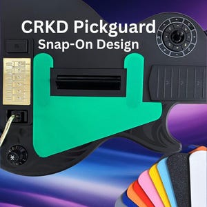 May include: A black guitar pickguard with a green accent and the text "CRKD Pickguard Snap-On Design." A variety of colorful pickguard replacements are displayed at the bottom. The pickguard has a gold-colored section with buttons.