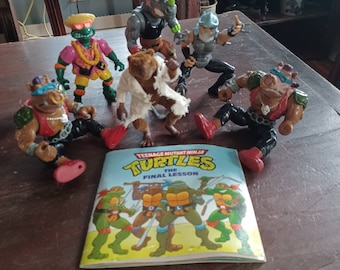 Vintage 90s Teenage Mutant Ninja Turtles action figure collection -  Shredder, Splinter, Donatello, Bebop, Rocksteady, stamped figures & book