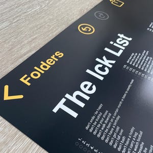 Puede incluir: Un cartel en blanco y negro con el texto "The Ick List" y una lista de cosas que no se deben hacer. La lista está numerada del 1 al 14. El cartel tiene una flecha amarilla que apunta hacia la izquierda y la palabra "Folders" sobre la flecha.