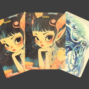 May include: Three fantasy art cards. Two cards depict a faerie with large eyes and pointed ears, and the word "FAERIE" printed at the top. The third card shows a blue and green sea creature. The cards have a vintage, illustrated style.