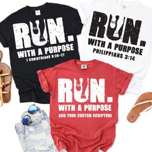 May include: Three short-sleeved t-shirts in black, white, and red. Each shirt features the text "RUN." with a graphic of running shoes inside the letter U, followed by "WITH A PURPOSE" and specific scripture references or custom text.