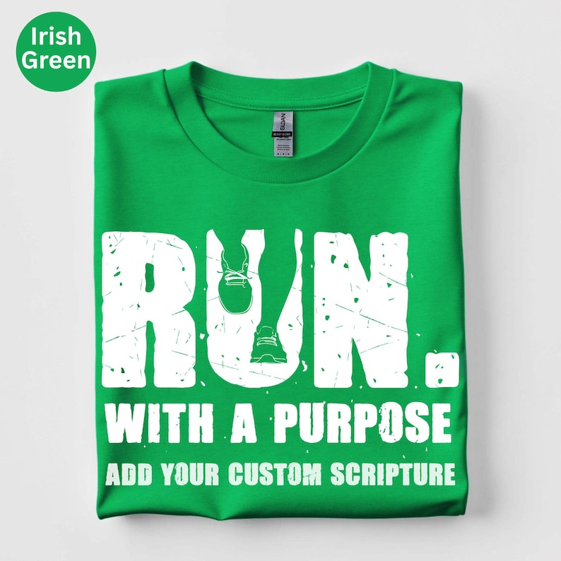 May include: An Irish green short-sleeve t-shirt featuring a white graphic with the text RUN. WITH A PURPOSE and ADD YOUR CUSTOM SCRIPTURE. The letter U in RUN is replaced by a graphic of running legs and trainers. The text has a distressed texture.