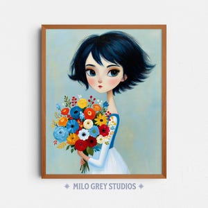 Puede incluir: Una impresión artística enmarcada que presenta una ilustración estilizada de una persona joven con cabello azul oscuro sosteniendo un colorido ramo de flores. La obra de arte tiene un estilo suave y pictórico con un fondo azul claro. El texto "MILO GREY STUDIOS" está en la parte inferior.