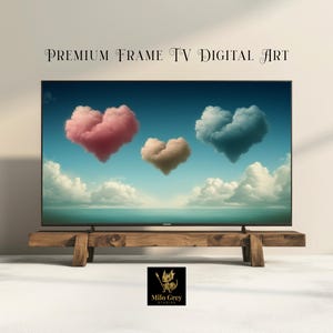 May include: A flat-screen TV displays digital art featuring three heart-shaped clouds in pink, tan, and blue against a blue sky. The TV sits on a rustic wooden stand. Text at the top reads "PREMIUM FRAME TV DIGITAL ART".