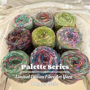 Könnte beinhalten: Neun Stränge farbenfrohen Faser-Kunstgarns in Grün-, Blau-, Rosa- und Lilatönen. Das Garn ist in einem Raster angeordnet. Der Text auf dem Bild lautet "Palette Series", "Limited Edition Fibre Art Yarn" und "100g pro Strang".