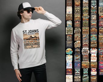 May include: White sweatshirt with a graphic design of a desert landscape and the text "ST. JOHNS ARIZONA". The graphic is in brown, orange, and beige colors.