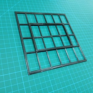 May include: A black plastic grid with a smaller grid inside. The grid is made of squares and is designed for organizing small items.
