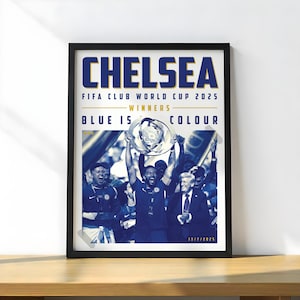 May include: A framed poster with the word "CHELSEA" in large blue letters. The poster commemorates the FIFA Club World Cup 2025 winners. The image shows a team celebrating with a trophy. The text "BLUE IS COLOUR" is also visible.