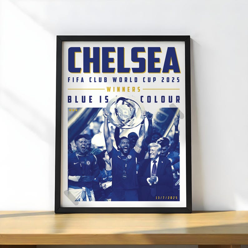 May include: A framed poster with the word "CHELSEA" in large blue letters. The poster commemorates the FIFA Club World Cup 2025 winners. The image shows a team celebrating with a trophy. The text "BLUE IS COLOUR" is also visible.