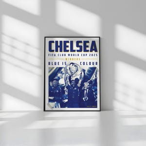 May include: Framed poster with the word "CHELSEA" in blue letters. The poster commemorates the FIFA Club World Cup 2025 victory, with the text "BLUE IS COLOUR". The image shows a team celebrating with a trophy.