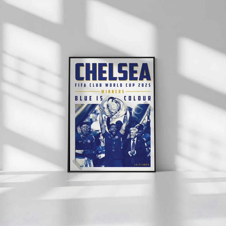 May include: Framed poster with the word "CHELSEA" in blue letters. The poster commemorates the FIFA Club World Cup 2025 victory, with the text "BLUE IS COLOUR". The image shows a team celebrating with a trophy.