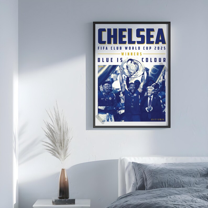 May include: A framed poster with the word "CHELSEA" in navy blue, with text below indicating "FIFA CLUB WORLD CUP 2025 WINNERS". The image shows a team celebrating with a trophy. The text "BLUE IS COLOUR" is also visible.