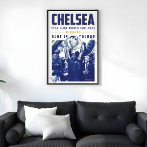 May include: A framed poster with the word "CHELSEA" in large blue letters at the top. Below, it reads "FIFA CLUB WORLD CUP 2025 - WINNERS - BLUE IS COLOUR". The image shows a team celebrating with a trophy.