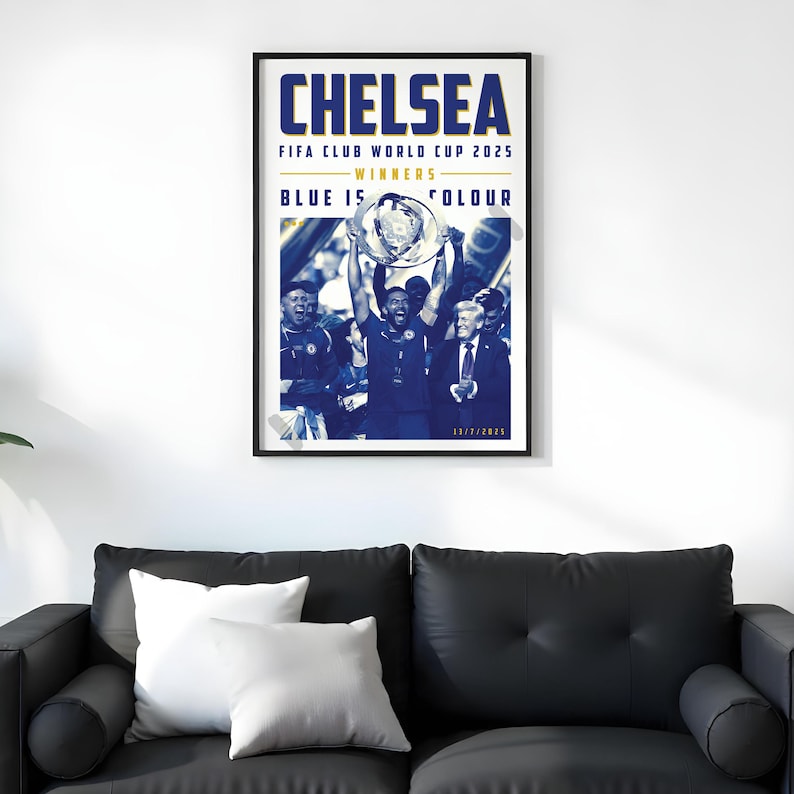 May include: A framed poster with the word "CHELSEA" in large blue letters at the top. Below, it reads "FIFA CLUB WORLD CUP 2025 - WINNERS - BLUE IS COLOUR". The image shows a team celebrating with a trophy.