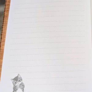 May include: White lined stationery paper with a cute gray and white cat illustration in the bottom left corner. The text "mofusand" is printed at the top center. Decorative star and dot designs are in the corners.