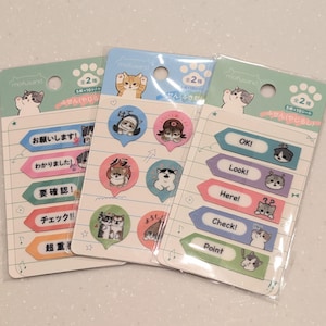 May include: Three packs of cat-themed sticky notes. Each pack features different designs, including speech bubbles and arrow-shaped notes. The notes have illustrations of cats and Japanese text. The packs are sealed in clear plastic.