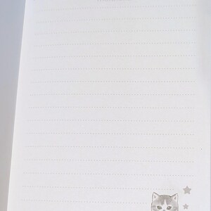 May include: Open notebook with lined pages and a decorative border. The word "mofusand" is printed at the top. A cartoon cat illustration is in the bottom right corner, with the word "@mofusand" below it.